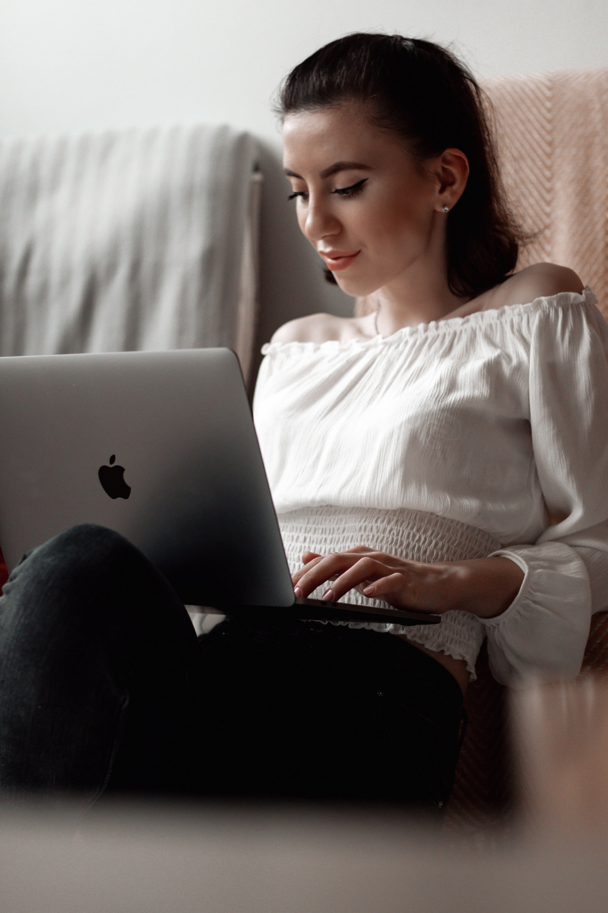 Woman sitting in a comfortable place at home with her computer. Doing a telehealth session from home.