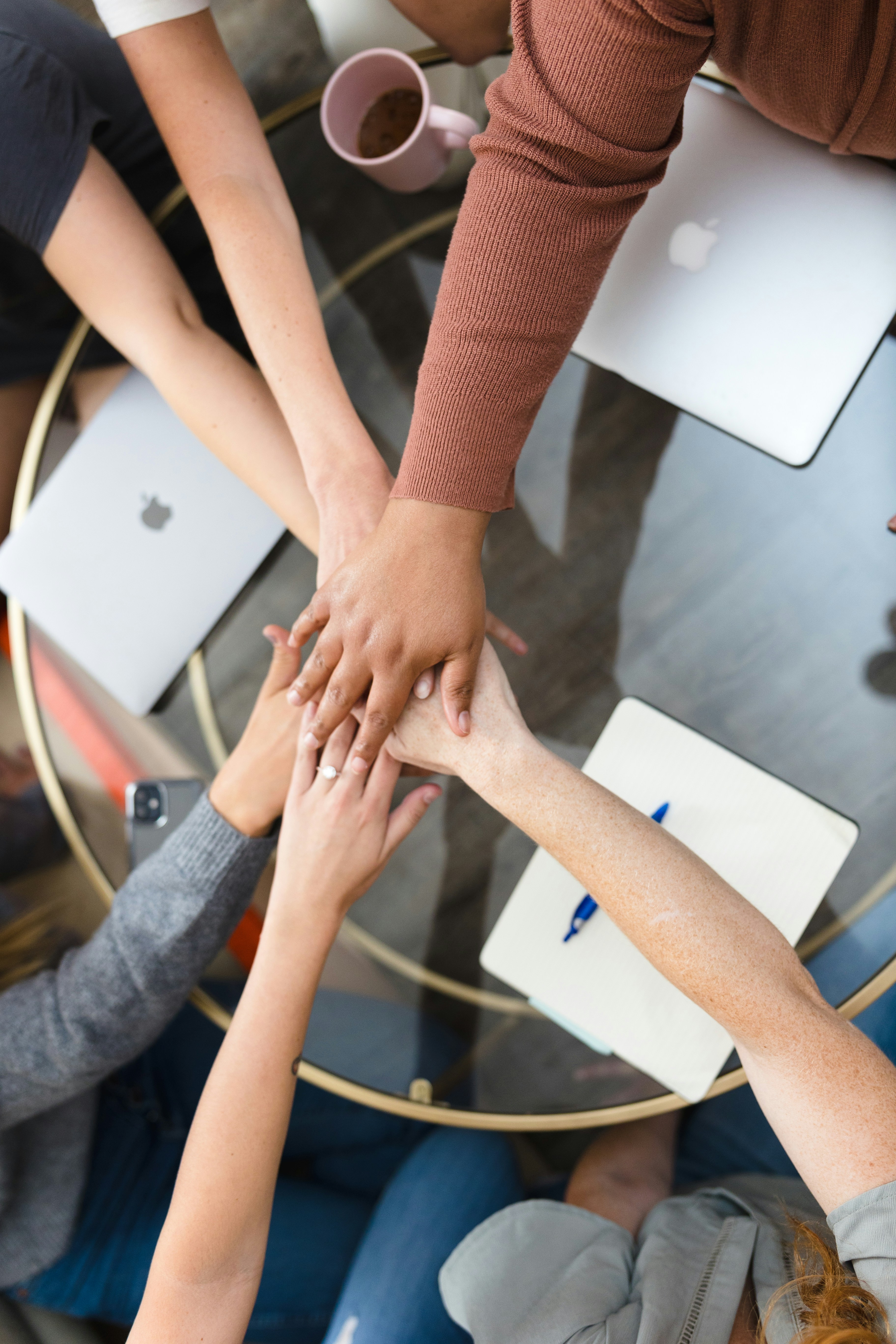 Co-workers huddling and high fiving.